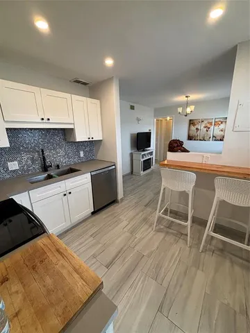 a kitchen with a sink chairs and cabinets