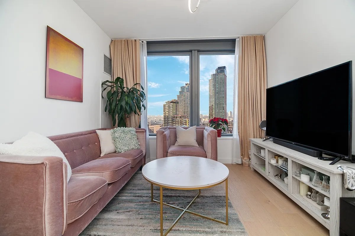 3 Court Square, Unit 1909 Queens, NY 11101 - Photo 2 of 6 a living room with furniture and a flat screen tv