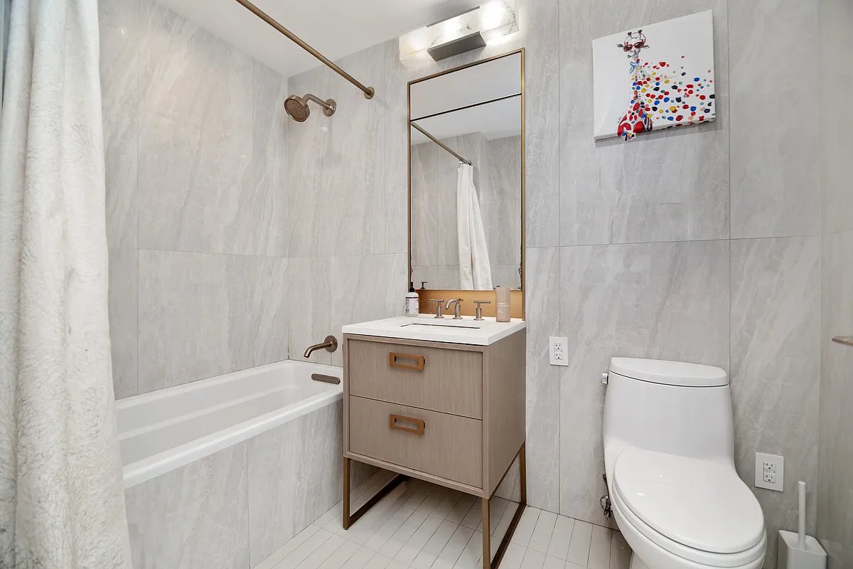 3 Court Square, Unit 1909 Queens, NY 11101 - Photo 6 of 6 a bathroom with a sink a mirror and a toilet