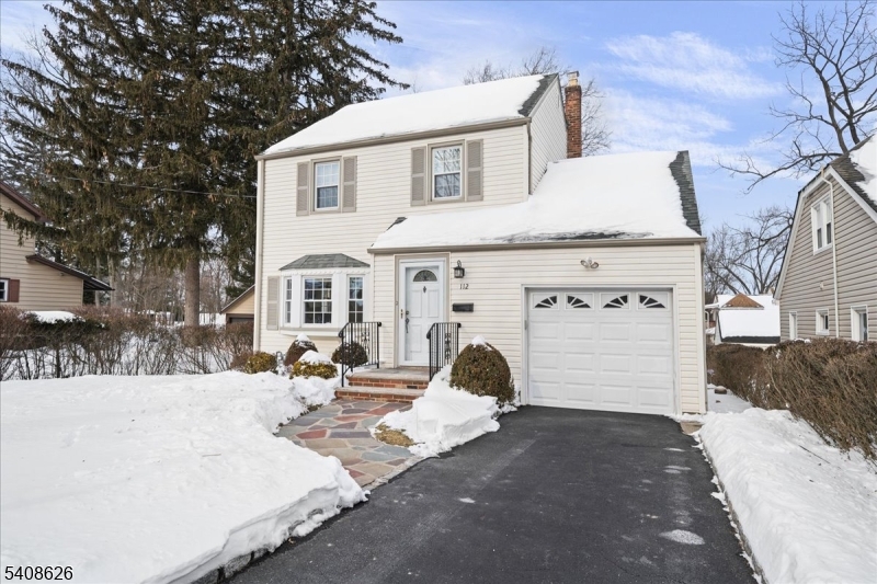a view of a white house with a large tree