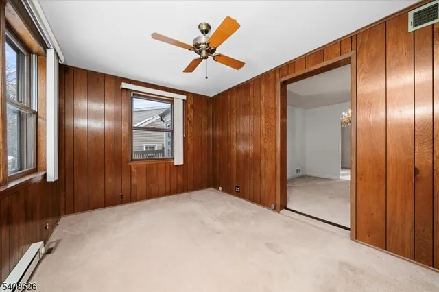 an empty room with chandelier fan