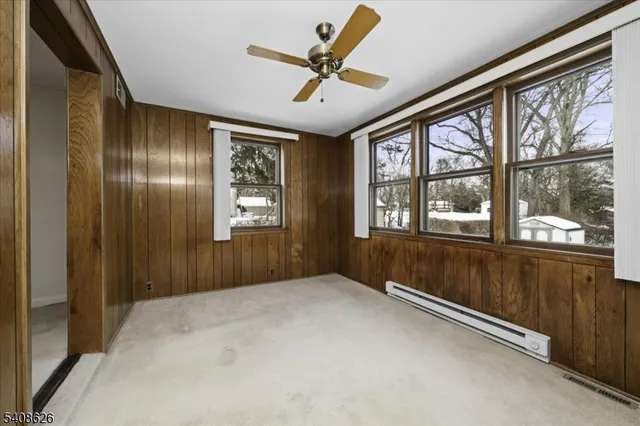 a view of a livingroom with a chandelier fan and windows