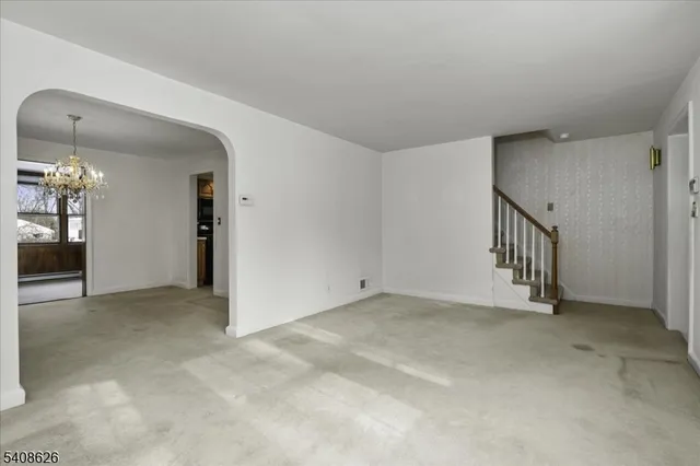 an empty room with chandelier and glass door