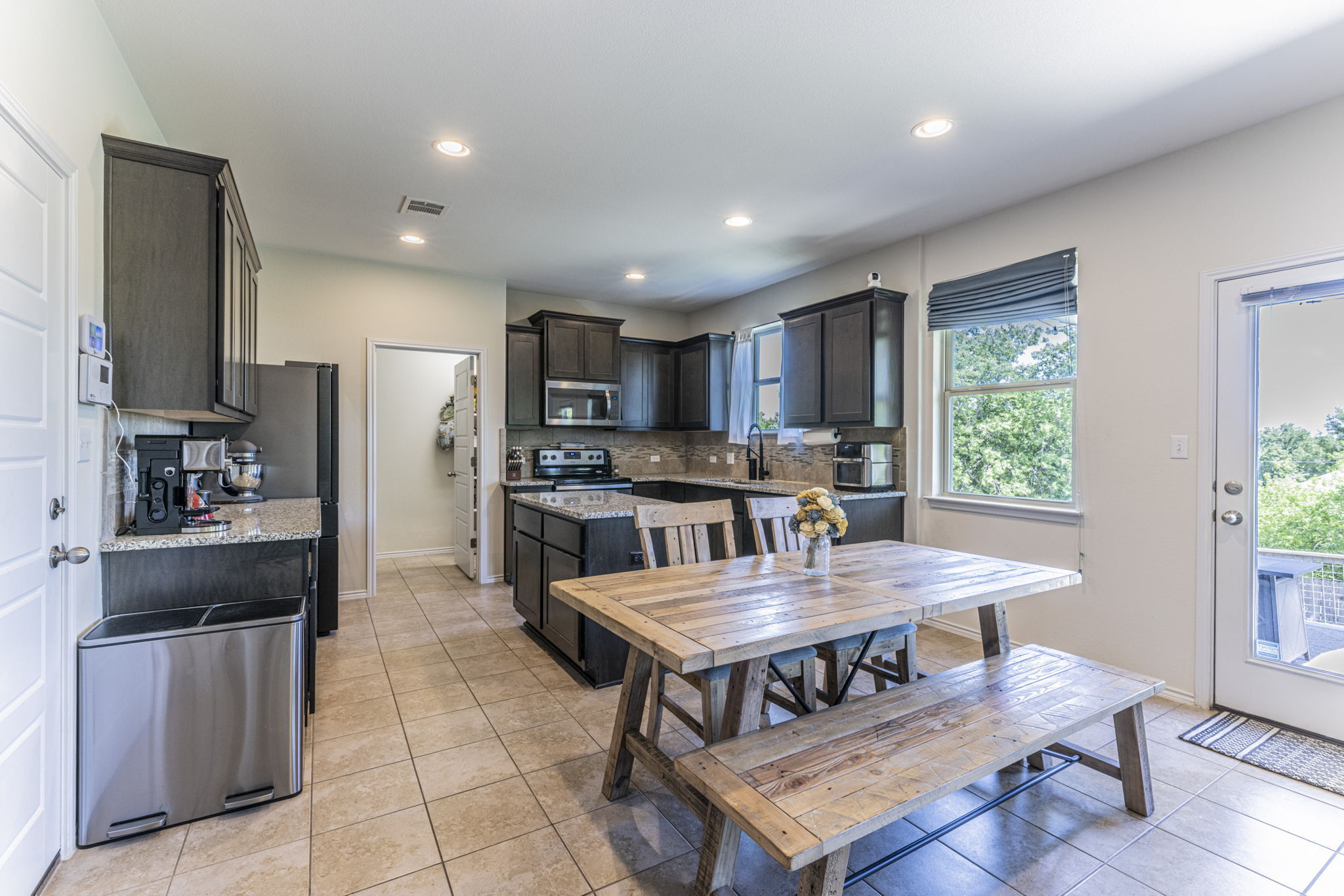20205 Navarre Terrace Pflugerville, TX 78660 - Photo 8 of 24 a kitchen with a dining table chairs and refrigerator