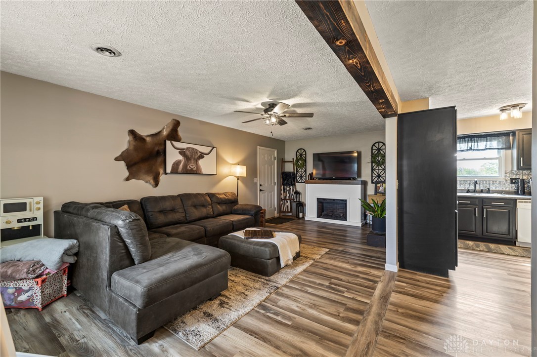 8969 Franklin-Trenton Road Franklin, OH 45005 - Photo 25 of 49 This inviting living area features warm wood flooring and a cozy fireplace, seamlessly connecting to the kitchen.