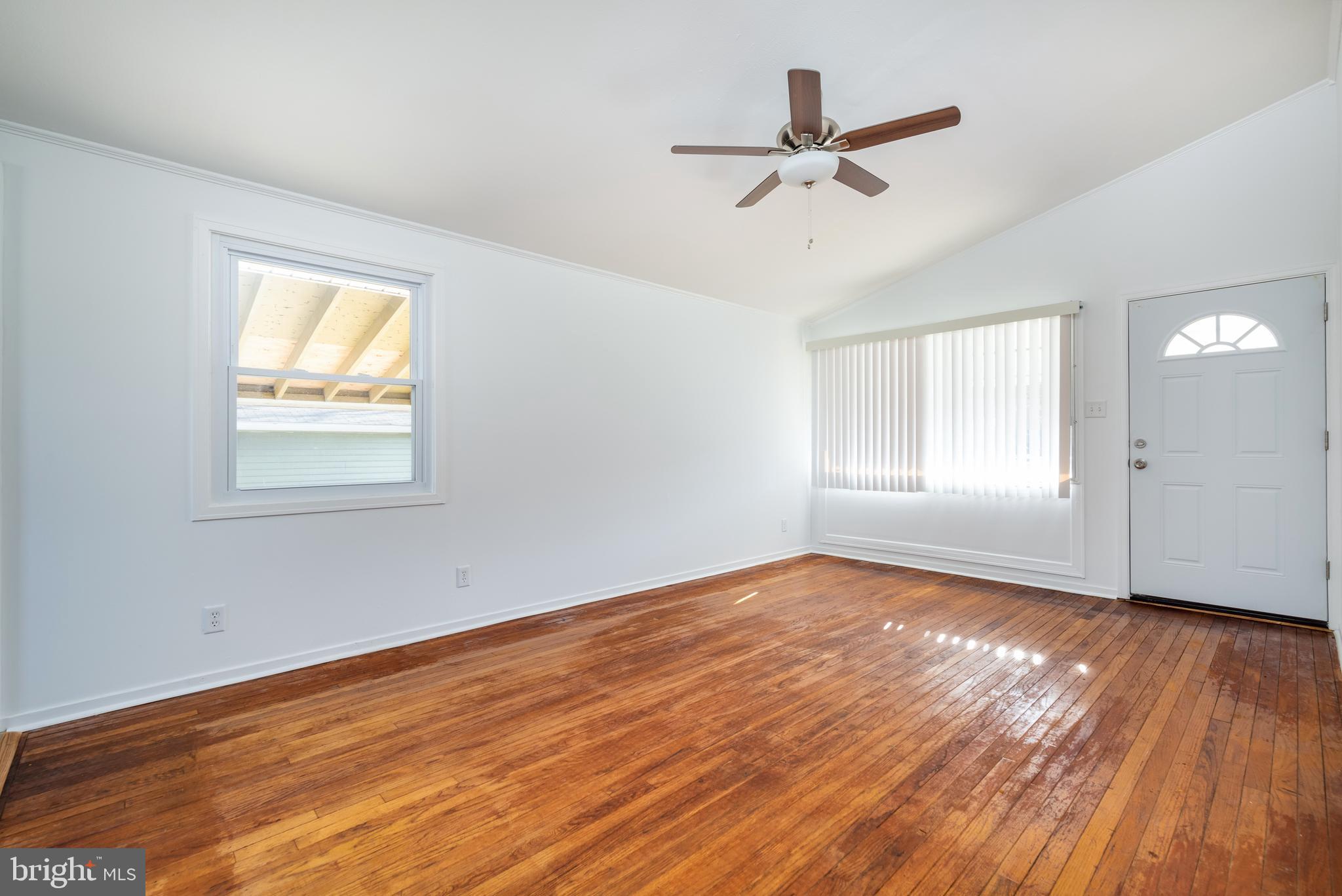 3005 Sollers Point Road Baltimore, MD 21222 - Photo 7 of 33 an empty room with wooden floor fan and windows