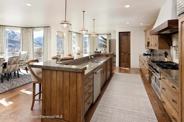 a kitchen with stainless steel appliances granite countertop a stove a sink and a refrigerator