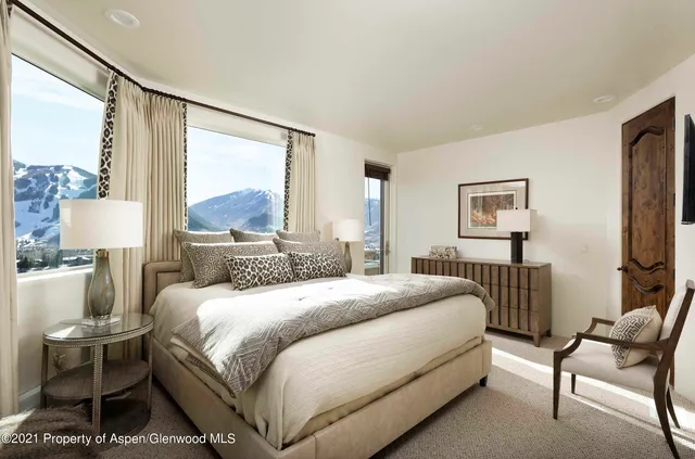 a bedroom with a bed and a large window