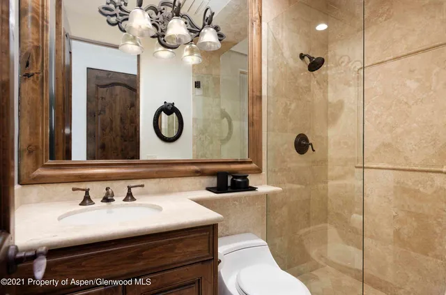 a bathroom with a sink a toilet and a mirror