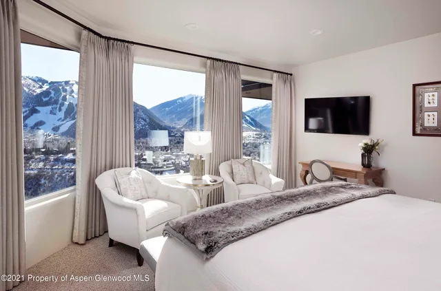 a spacious bedroom with a large bed and a flat screen tv