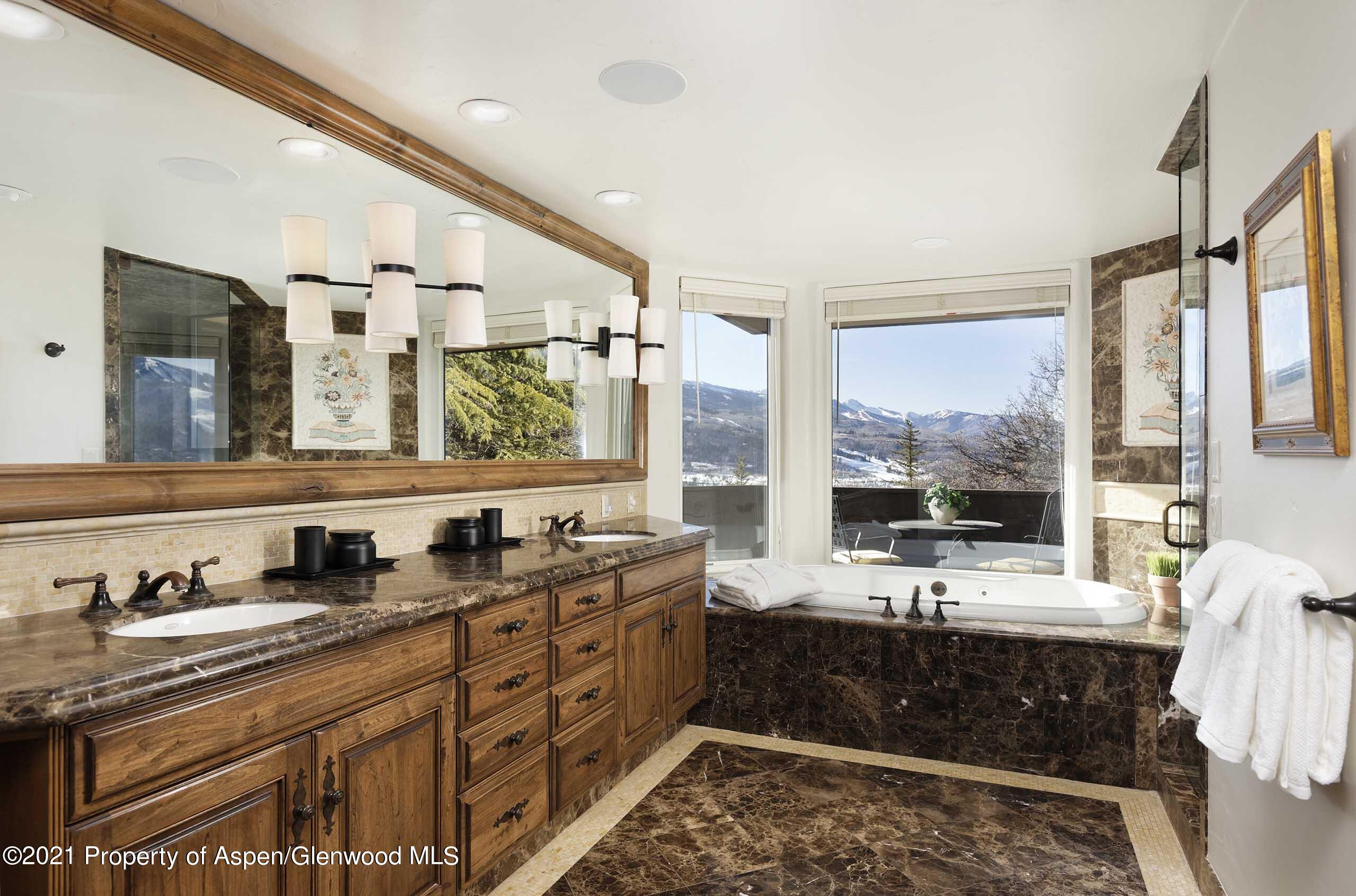 476 Wrights Road Aspen, CO 81612 - Photo 24 of 37 a bathroom with double vanity sinks a large mirror and a bathtub next to a window