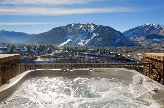 a view of a swimming pool with a table and chairs under an umbrella