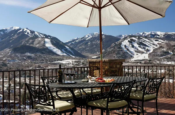 a view of a patio with a table and chairs under an umbrella