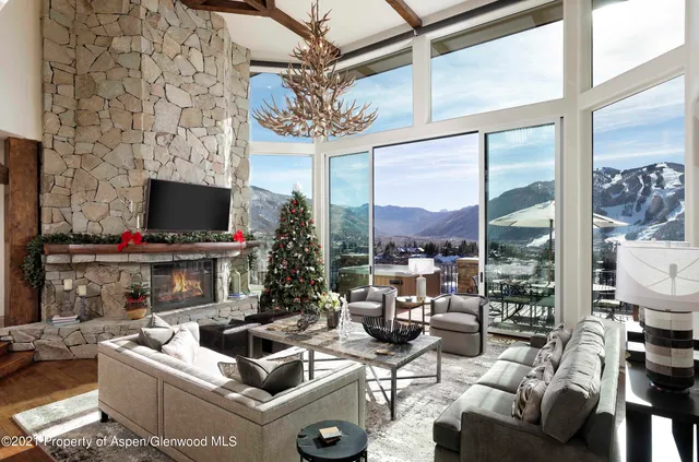 a living room with furniture a flat screen tv and a floor to ceiling window
