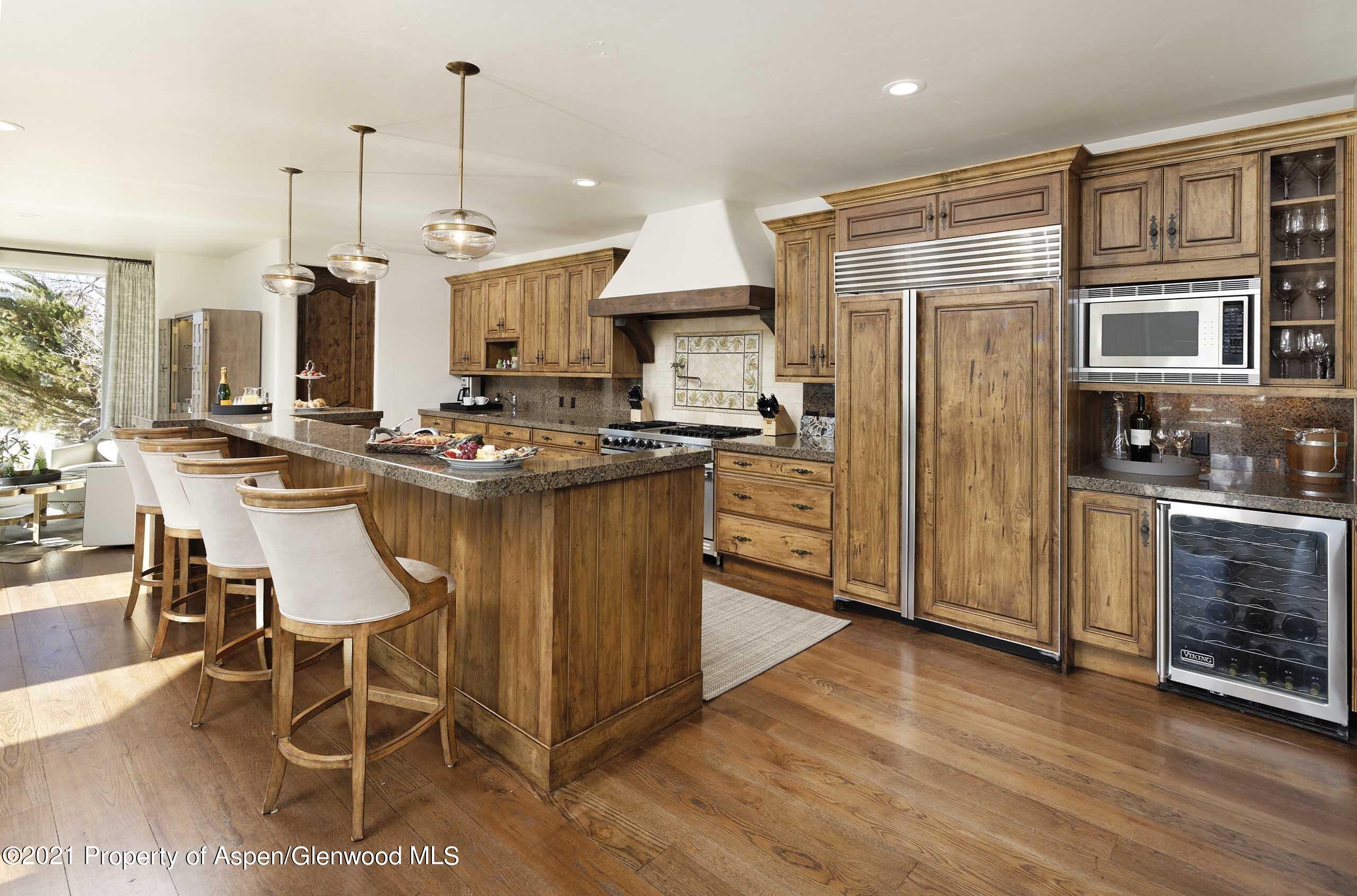 476 Wrights Road Aspen, CO 81612 - Photo 10 of 37 a kitchen with stainless steel appliances granite countertop a stove top oven a sink dishwasher a dining table and chairs with wooden floor