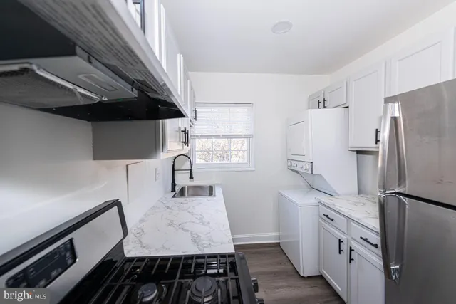 a kitchen with granite countertop a refrigerator stove and sink