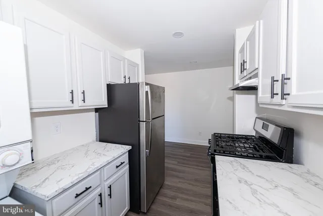 a kitchen with stainless steel appliances granite countertop a refrigerator and a stove