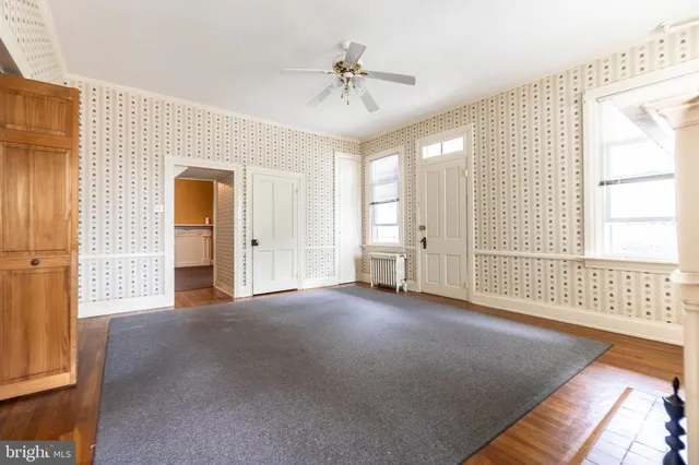 an empty room with closet and a ceiling fan