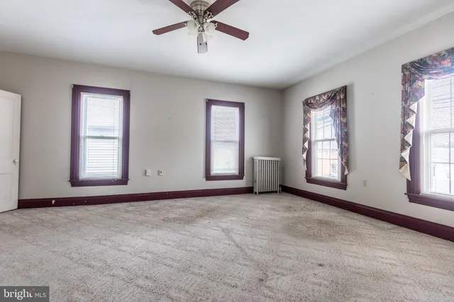 a view of a livingroom with a ceiling fan and window