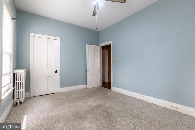 an empty room with chandelier fan