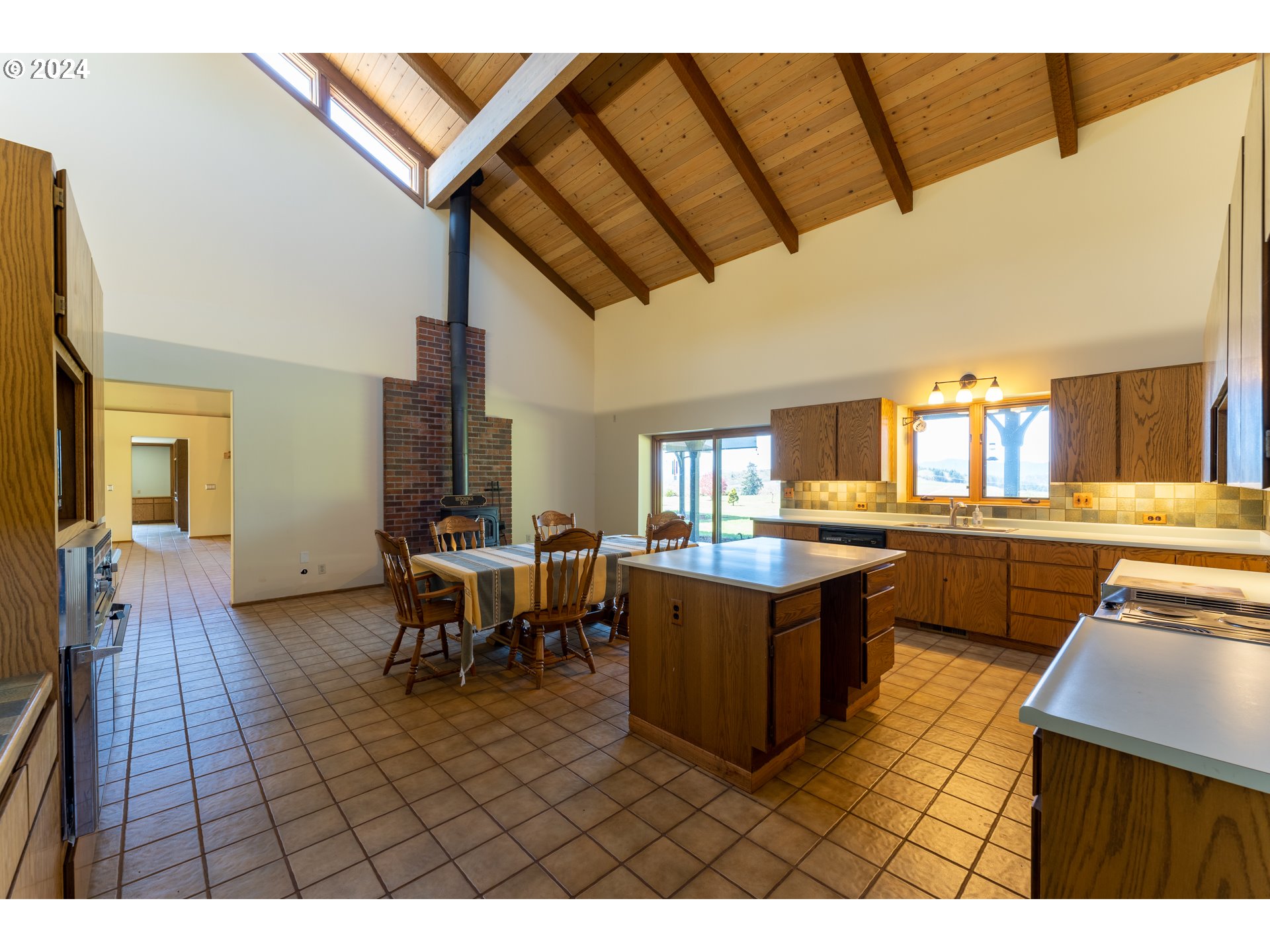 1488 Red Hill Road Oakland, OR 97462 - Photo 19 of 35 a open kitchen with stainless steel appliances kitchen island granite countertop a table and chairs