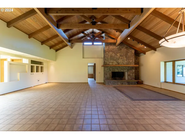 a view of an empty room with a fireplace and wooden floor