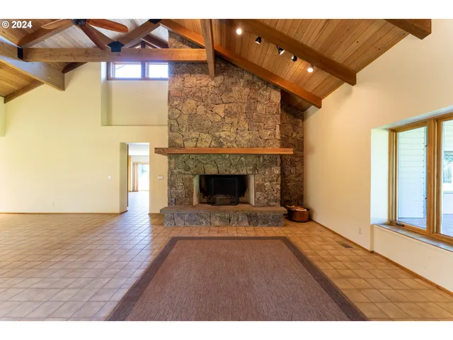 a view of an empty room with wooden floor and a fireplace