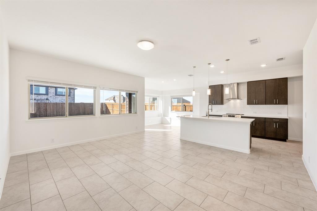 3665 Jordan Way Kaufman, TX 75142 - Photo 6 of 34 a large white kitchen with kitchen island a sink a counter top and a stove top oven