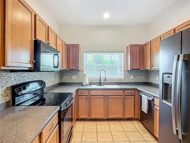 a kitchen with a sink a stove and cabinets