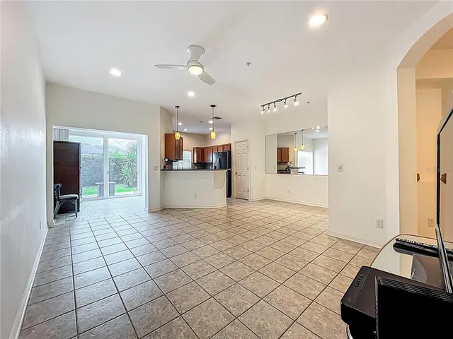 a view of a kitchen with kitchen island granite countertop a refrigerator and a stove top oven