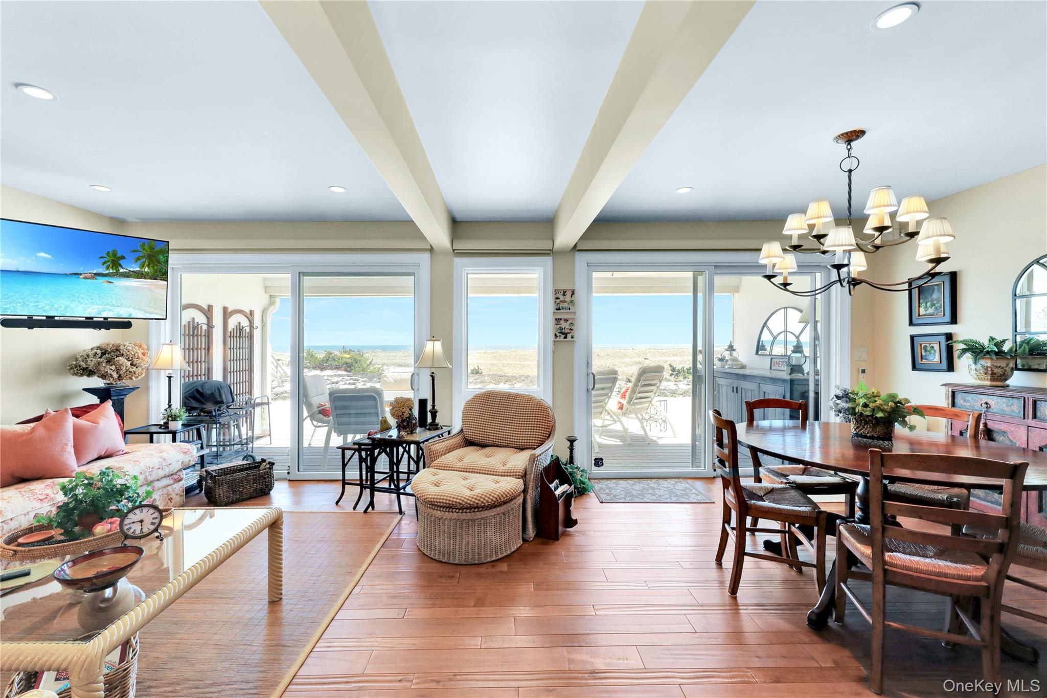 279 Dune Road, Unit 2 Westhampton Beach, NY 11978 - Photo 7 of 45 a living room with fireplace furniture and a chandelier