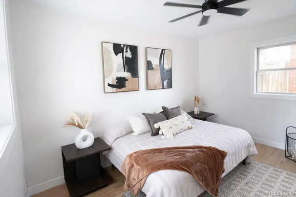 a bedroom with a bed and painting on the wall