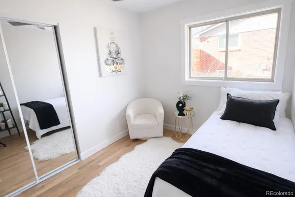 a bedroom with a bed and a chair with window