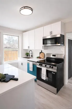 a kitchen with stainless steel appliances a stove a sink and a microwave