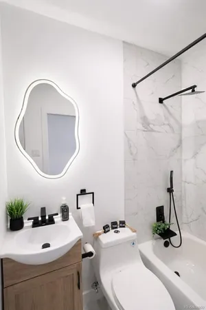 a bathroom with a sink a toilet and a mirror