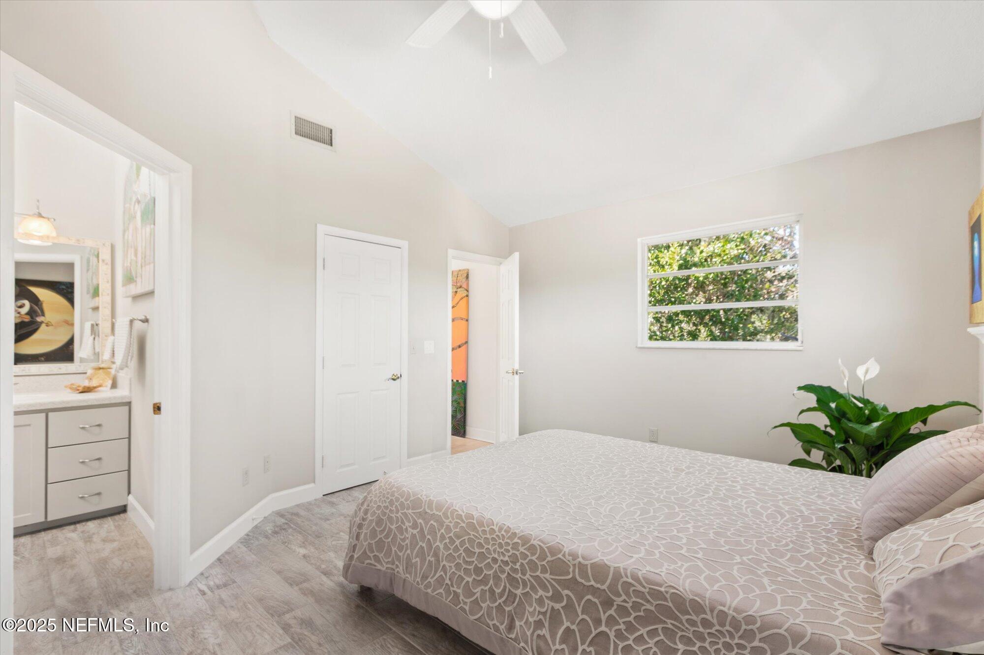 1685 Santander Street St. Augustine, FL 32080 - Photo 15 of 48 a bedroom with a bed and a potted plant
