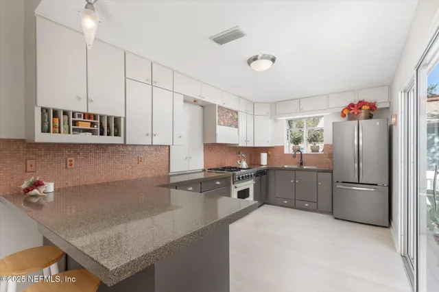 a kitchen with granite countertop cabinets stainless steel appliances and wooden floor