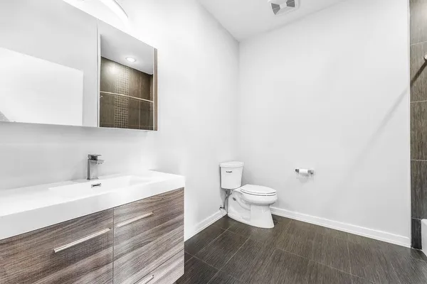 a bathroom with a sink a toilet and mirror