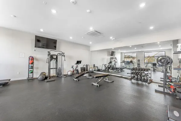 a view of a room with gym equipment and a large mirror