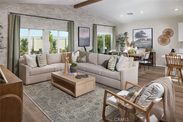 a living room with furniture wooden floor and a large window