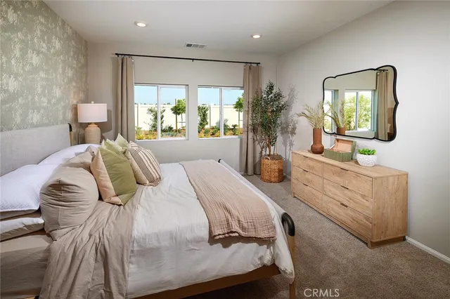 a bedroom with a bed mirror and window