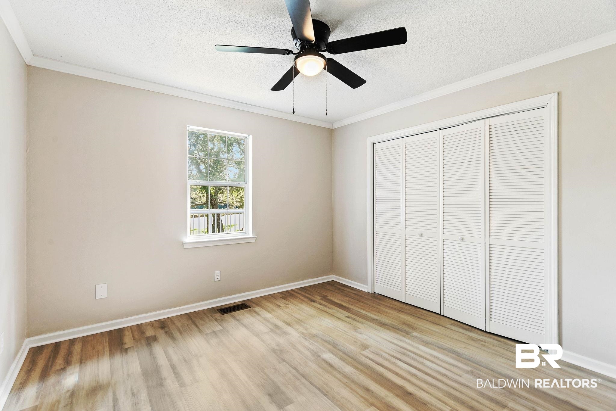 35650 Spring Road North Stapleton, AL 36578 - Photo 41 of 70 Unfurnished bedroom featuring crown molding, a textured ceiling, light wood-type flooring, a closet, and a ceiling fan