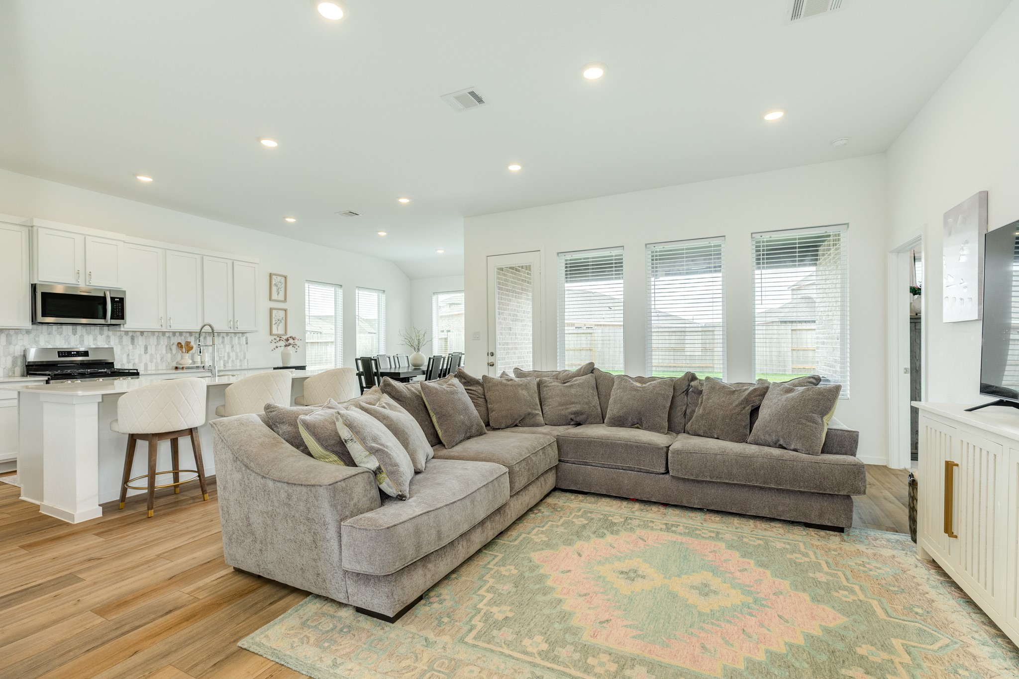 2618 Jasper Oaks Drive Rosharon, TX 77583 - Photo 10 of 43 Spacious family room featuring an open layout with large windows, allowing abundant natural light, and complemented by recessed lighting.
