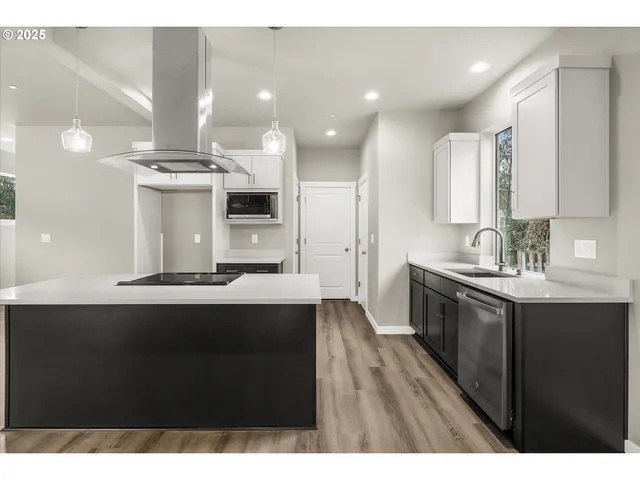 a kitchen with kitchen island a sink appliances and cabinets