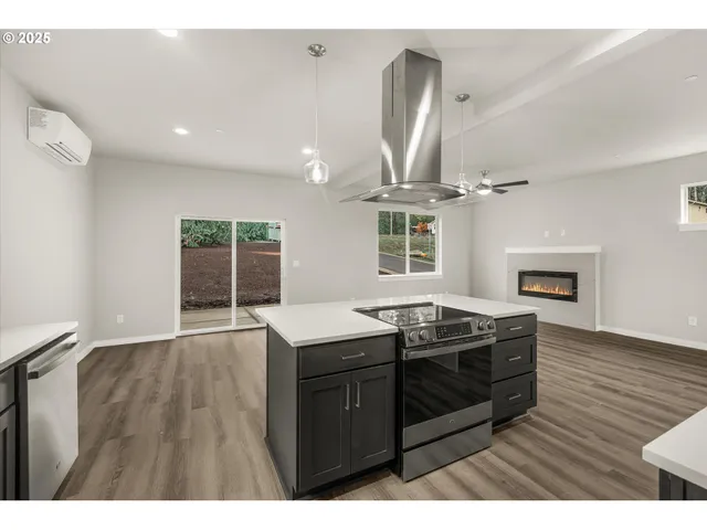 a kitchen with granite countertop a stove a sink and a wooden floors