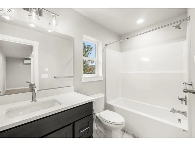 a bathroom with a sink a toilet a mirror and shower