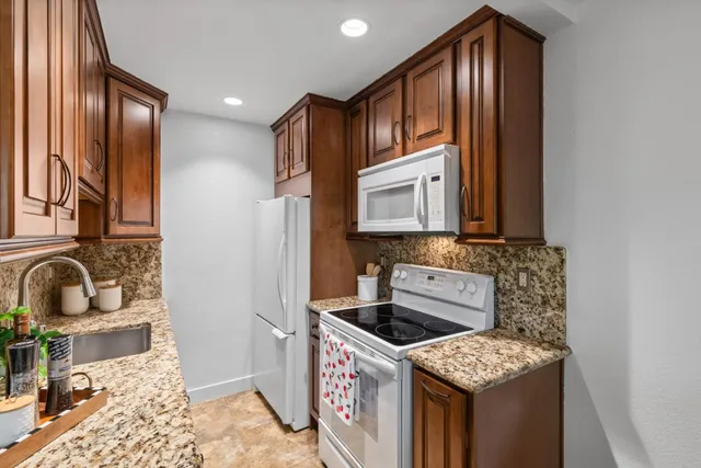 a kitchen with stainless steel appliances granite countertop a sink stove and cabinets