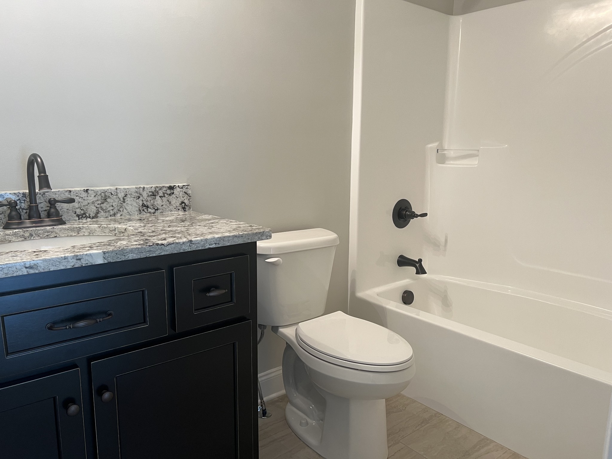 1012 Hideaway Road Columbia, TN 38401 - Photo 17 of 21 a bathroom with a granite countertop toilet a sink and bathtub