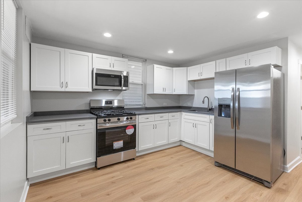3709 North Troy Street, Unit 1 Chicago, IL 60618 - Photo 2 of 12 a kitchen with stainless steel appliances granite countertop a stove a sink and a refrigerator