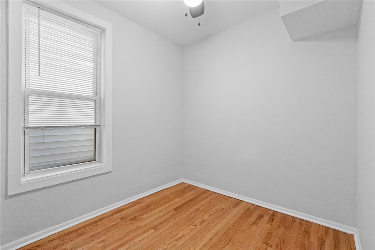3709 North Troy Street, Unit 1 Chicago, IL 60618 - Photo 4 of 12 a view of empty room with wooden floor and fan